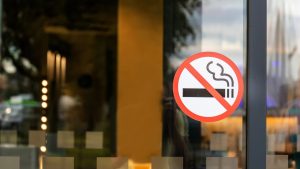 A no smoking in this building sign would appear in which colour circle?